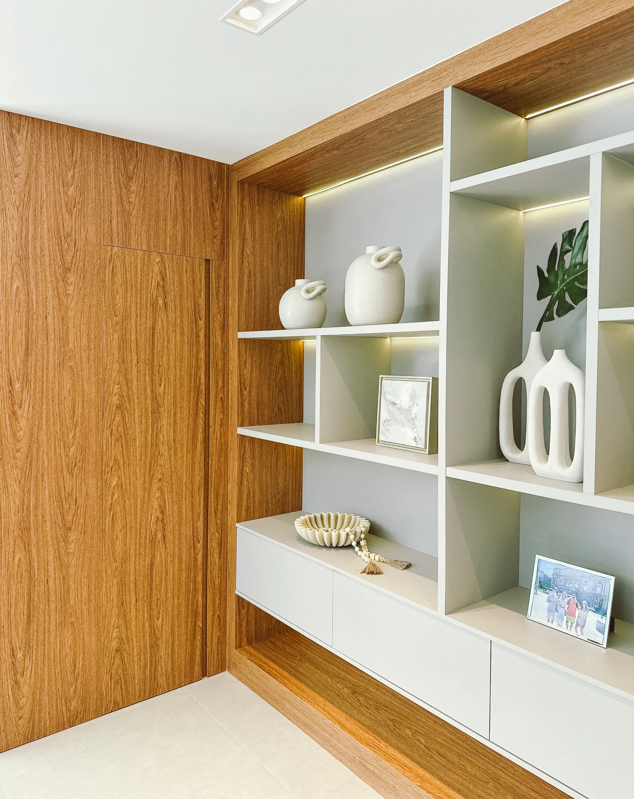 Interior minimalista de apartamento de alto padrão com painel de madeira e iluminação ambiente